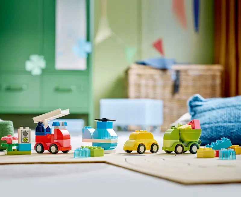 Lego DUPLO 10474 Creative Vehicles set with colorful toy trucks and cars for young children, assembled on a white background.