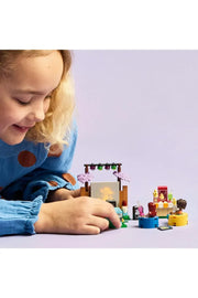 LEGO 42642 Friendship Movie Night set featuring LEGO minifigures and detailed movie-themed accessories on a colorful background.
